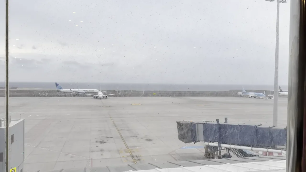 aircraft on the apron and the sea beyond seen through a dusty lounge window